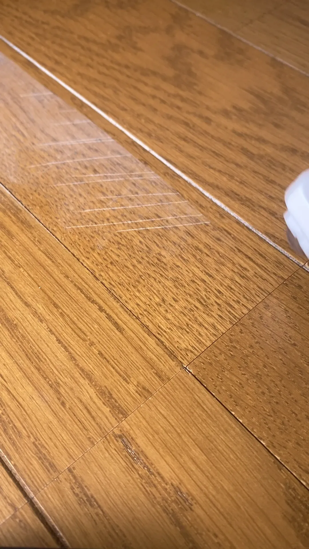 ペンで塗った範囲の白い線が見えにくくなったフローリング（補修後）